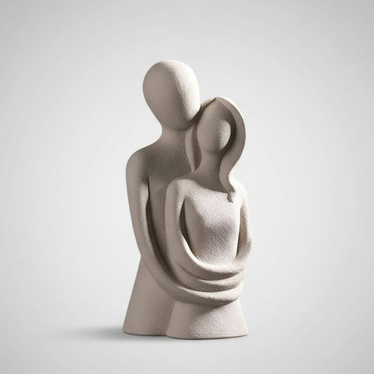 Abstract sculpture of two figures on a marble surface with a mirror reflection.